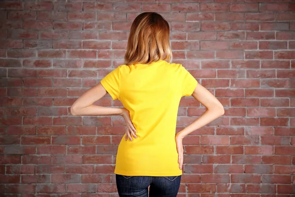 Νεαρή γυναίκα στο κενό κίτρινο t-shirt — Φωτογραφία Αρχείου