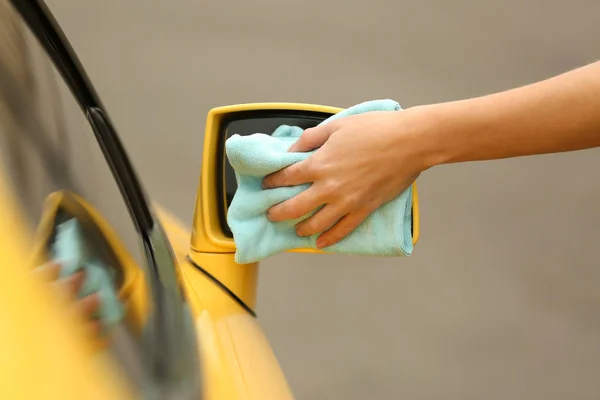 Mujer limpieza de manos coche amarillo — Foto de Stock