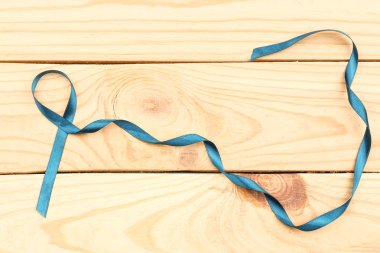 Sea-green ribbon on wooden background. clipart
