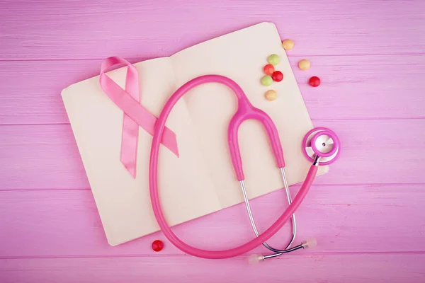 Stethoscope with pink ribbon and book — Stock Photo, Image