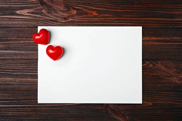 Red plastic hearts and paper — Stock Photo, Image