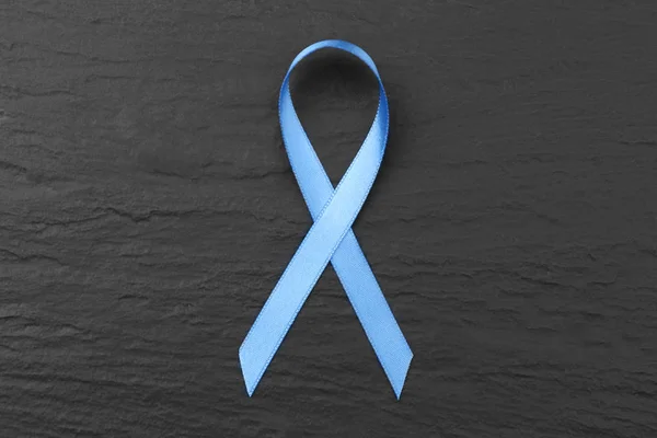 Light blue ribbon on dark textured background.