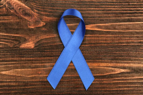 Blue ribbon on wooden background. — Stock Photo, Image