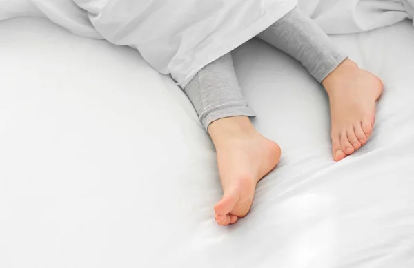ベッドの中で女性の足 — ストック写真