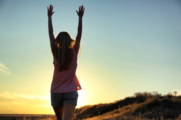 Silhouette of woman on sunset sky  