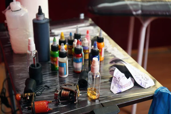 Tattoo master workplace with colorful inks and instruments, close up view — Stock Photo, Image