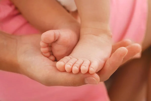 Mulher mão segurando bebê pés — Fotografia de Stock