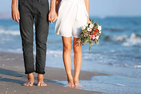 Joven pareja feliz con flores — Foto de Stock