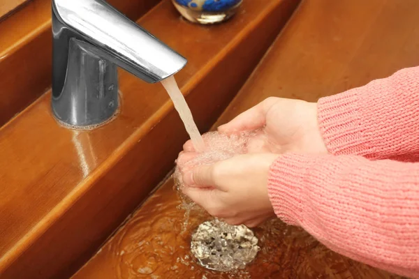 Jovem mulher lavando as mãos na pia — Fotografia de Stock