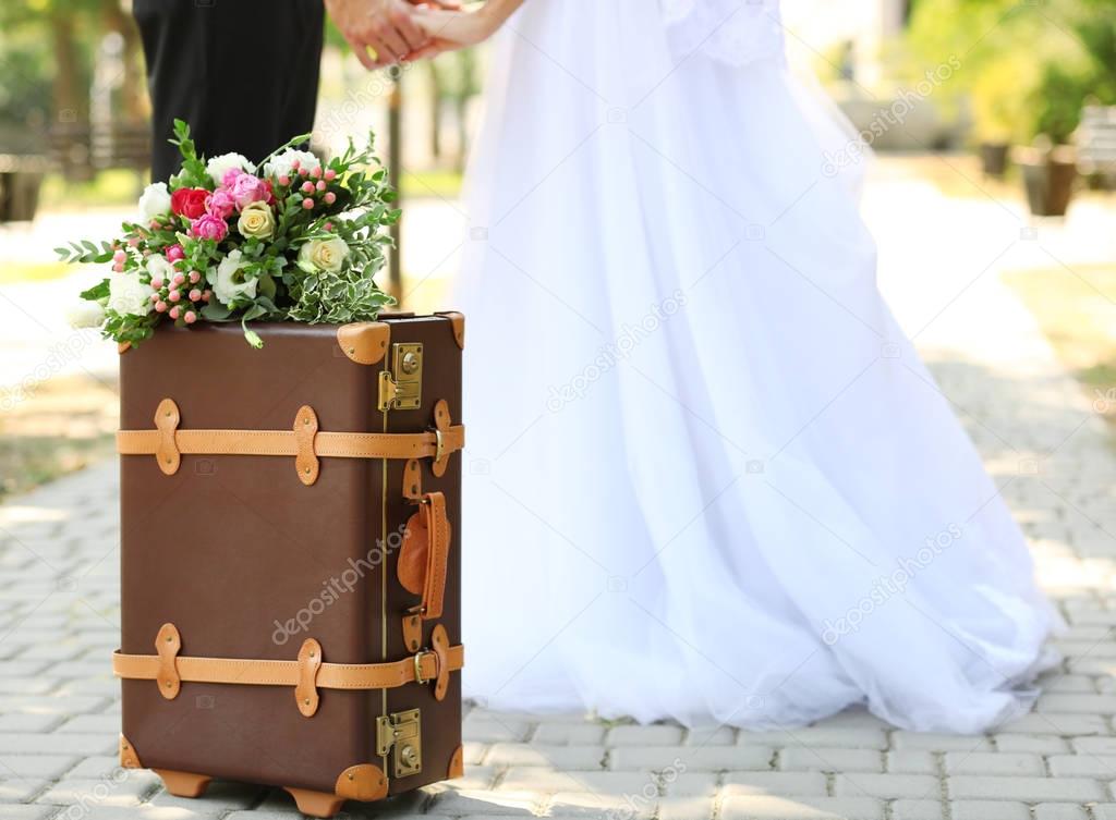 Vintage suitcase and groom with bride