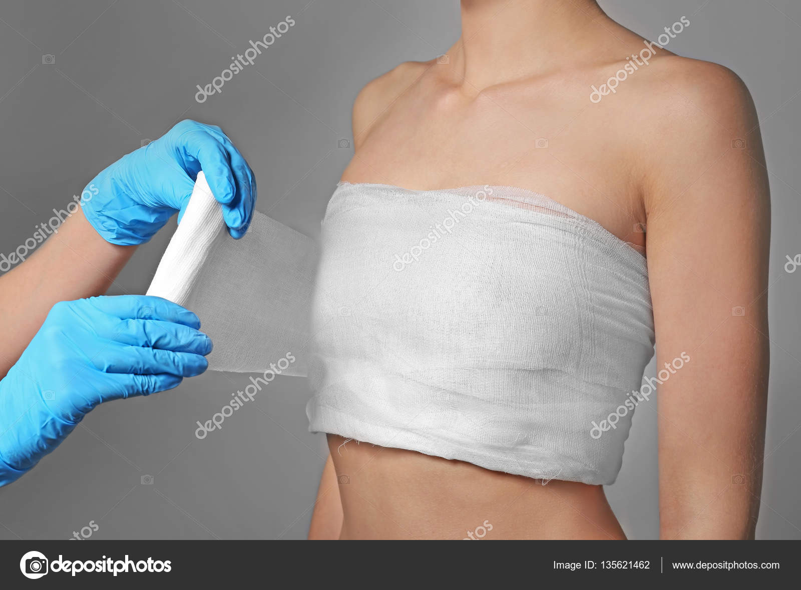 Doctor wrapping bandage around chest Stock Photo by ©belchonock