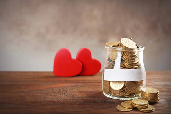 Jar with coins and hearts — Stock Photo, Image