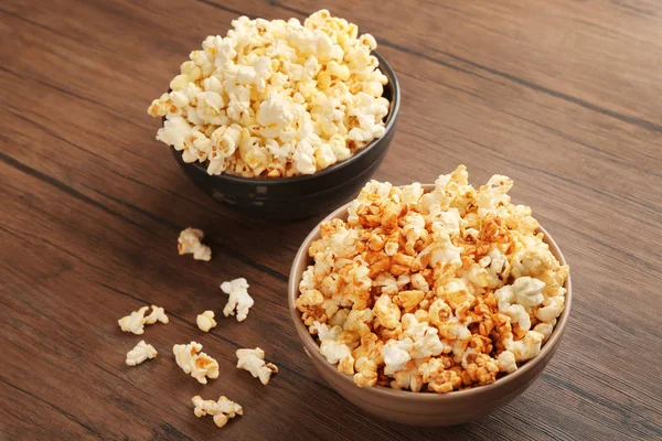 Popcorn in bowls on wooden table — Stock Photo, Image