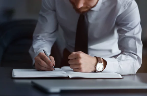 Geschäftsmann schreibt in Notizblock — Stockfoto