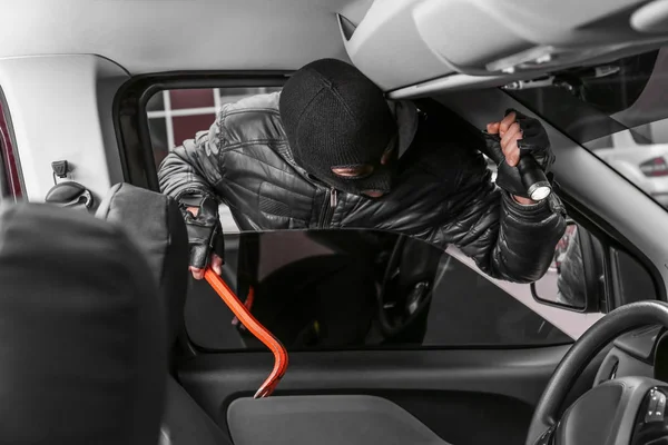 Чоловік злодій потрапляє в машину — стокове фото