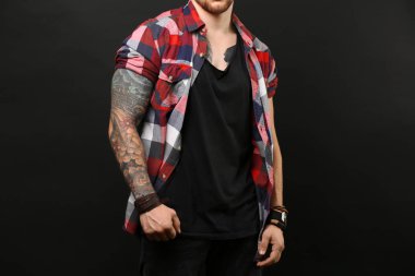 Koyu arka plan üzerinde poz genç dövmeli adam
