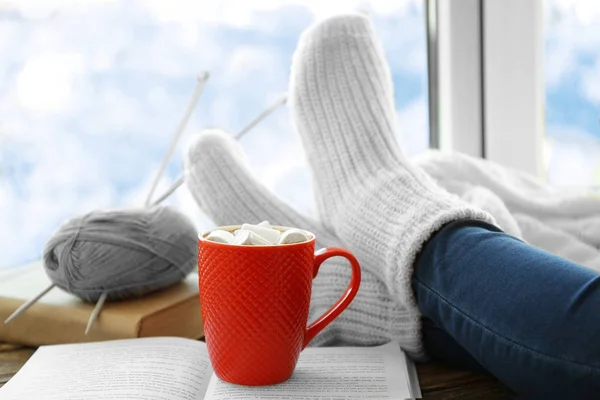 Menselijke benen naast kopje koffie — Stockfoto