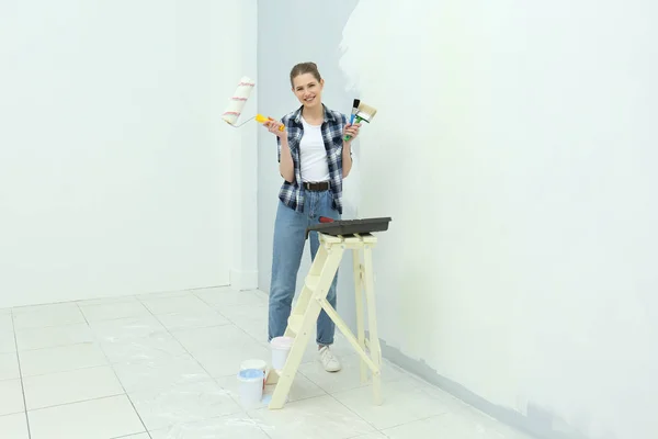 Hermosa joven mujer haciendo reparación en la habitación — Foto de Stock