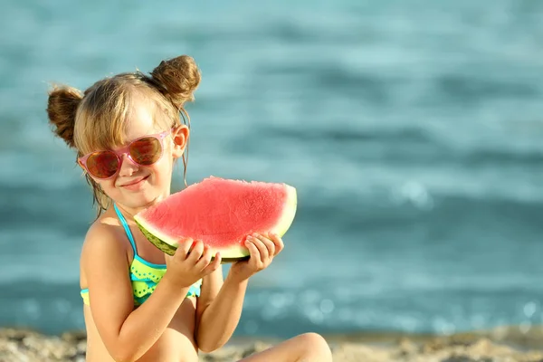 Menina bonito comer melancia na praia — Fotografia de Stock