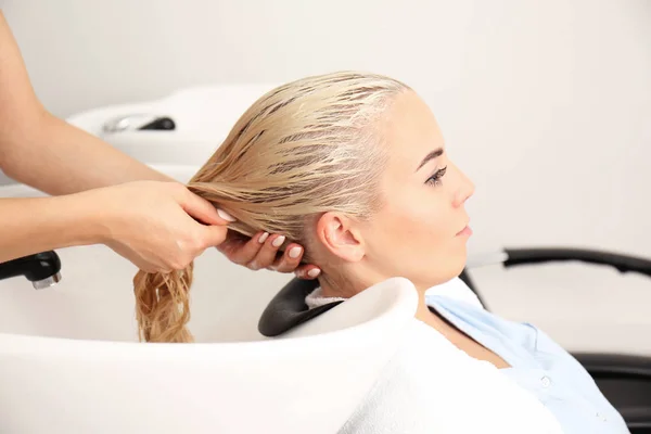 Hairdresser washing woman's hair — Stock Photo, Image