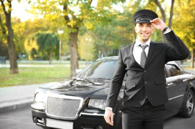 Young chauffeur adjusting hat 