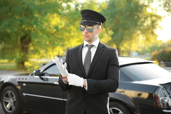 Junger Chauffeur richtet Handschuhe ein — Stockfoto