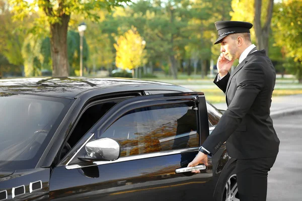 Chauffeur speaking by cellphone — Stock Photo, Image