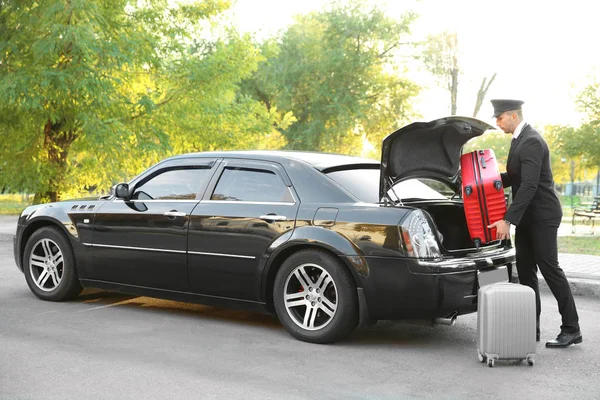 Chauffeur putting suitcase — Stock Photo, Image