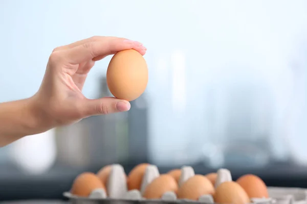 Ręka trzyma surowe jajko — Zdjęcie stockowe