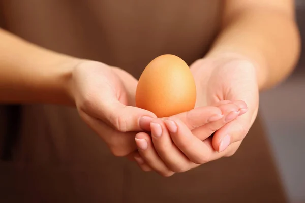 Kobiece ręce trzymając jajko — Zdjęcie stockowe