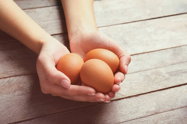 Mujer sosteniendo huevos crudos — Foto de Stock