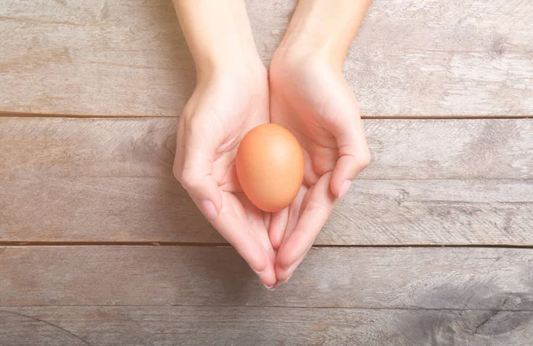 Woman holding raw egg — Stock Photo, Image