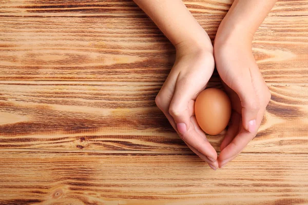 Woman holding raw egg — Stock Photo, Image