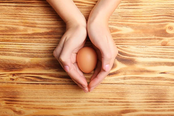 Woman holding raw egg — Stock Photo, Image