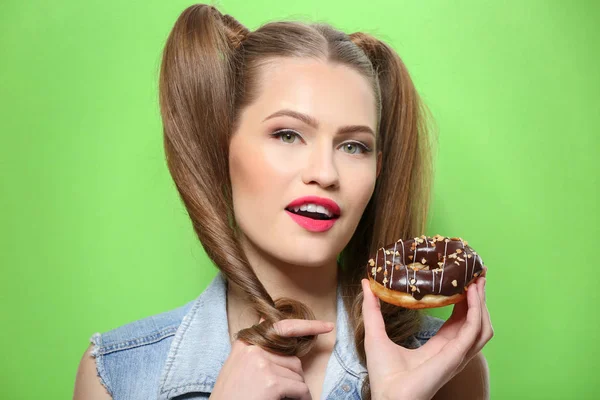 Mujer joven divertida con sabroso donut sobre fondo verde, de cerca —  Fotos de Stock