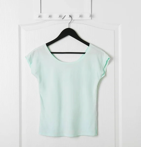 Blank t-shirt hanging on door — Stock Photo, Image