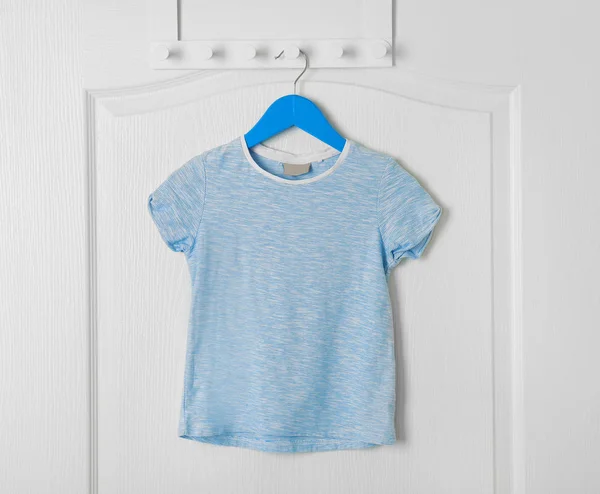 Пустая футболка висит на двери — стоковое фото