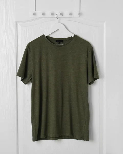 Blank t-shirt hanging on door