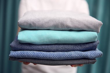 Katlanmış elbise tutan kadın