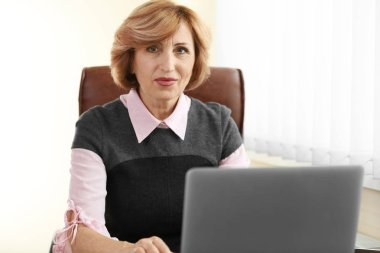 Senior businesswoman working with laptop clipart