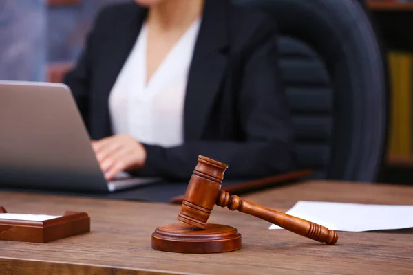 Martillo marrón sobre mesa de madera y abogada sobre fondo, vista de cerca — Foto de Stock