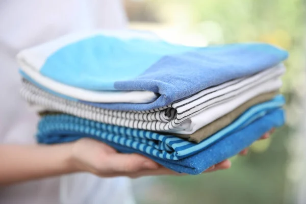 Mujer sosteniendo ropa doblada — Foto de Stock