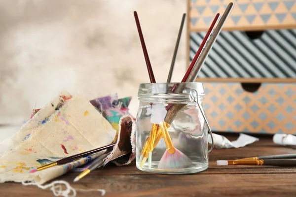 Brushes in jar with water — Stock Photo, Image