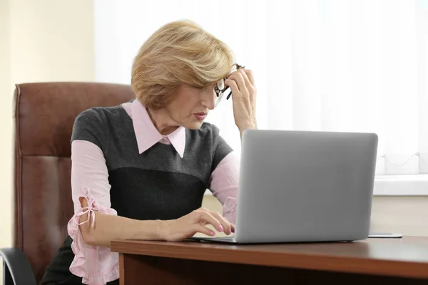 Старшая деловая женщина страдает от головной боли — стоковое фото