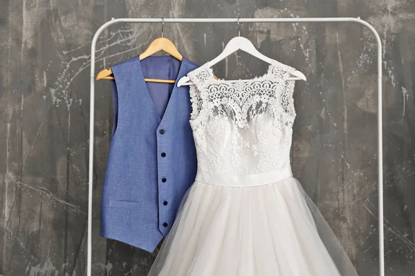 Платье невесты и костюм жениха в гримерке в помещении — стоковое фото