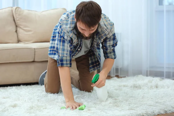 Śmieszne, młody człowiek, czyszczenie dywanów w domu — Zdjęcie stockowe