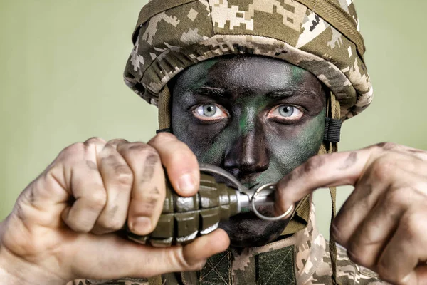 Vista de perto do soldado puxando pino de segurança da granada de fragmentação, sobre fundo cinza — Fotografia de Stock
