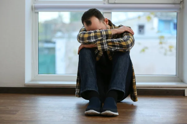 Hombre deprimido sentado en el suelo — Foto de Stock