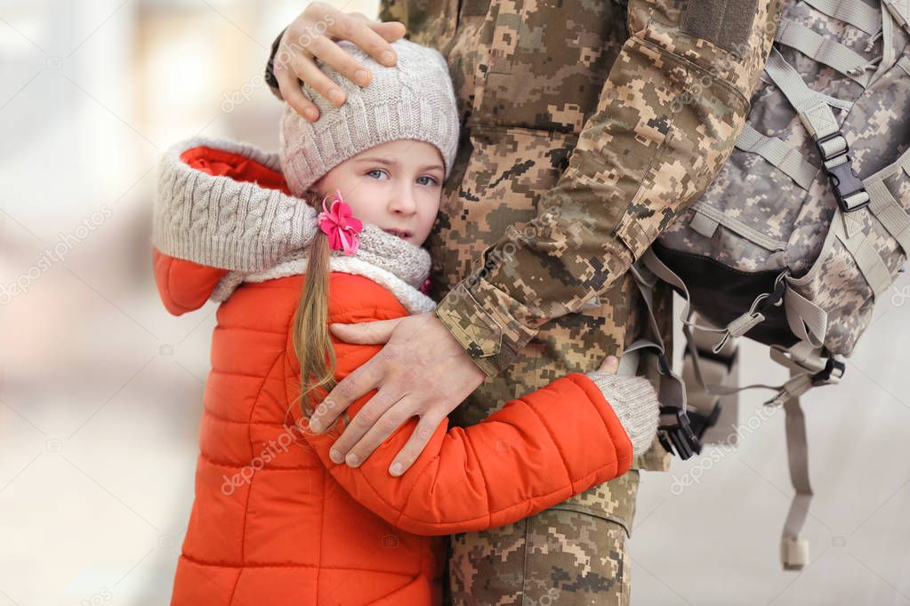 Little girl and her father in military uniform outdoors