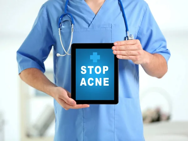 Dermatologist with tablet on blurred background. Text STOP ACNE on screen — Stock Photo, Image